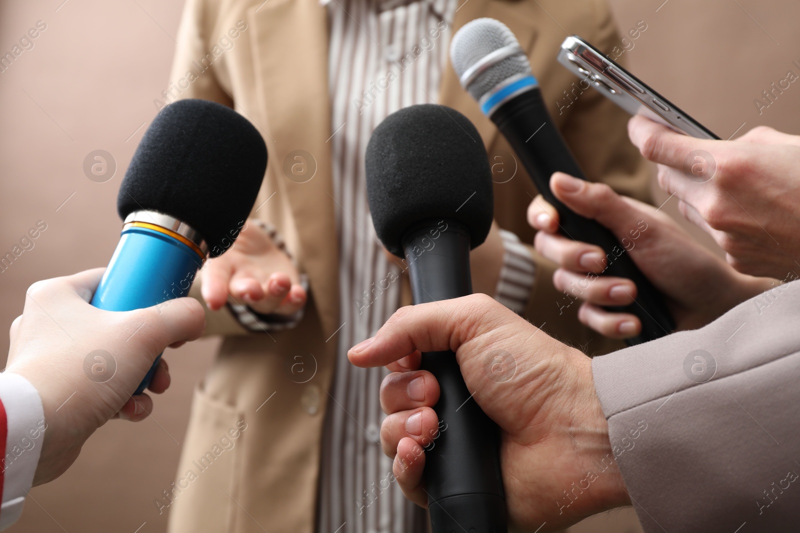 Photo of Group of journalists interviewing businesswoman on beige background, closeup