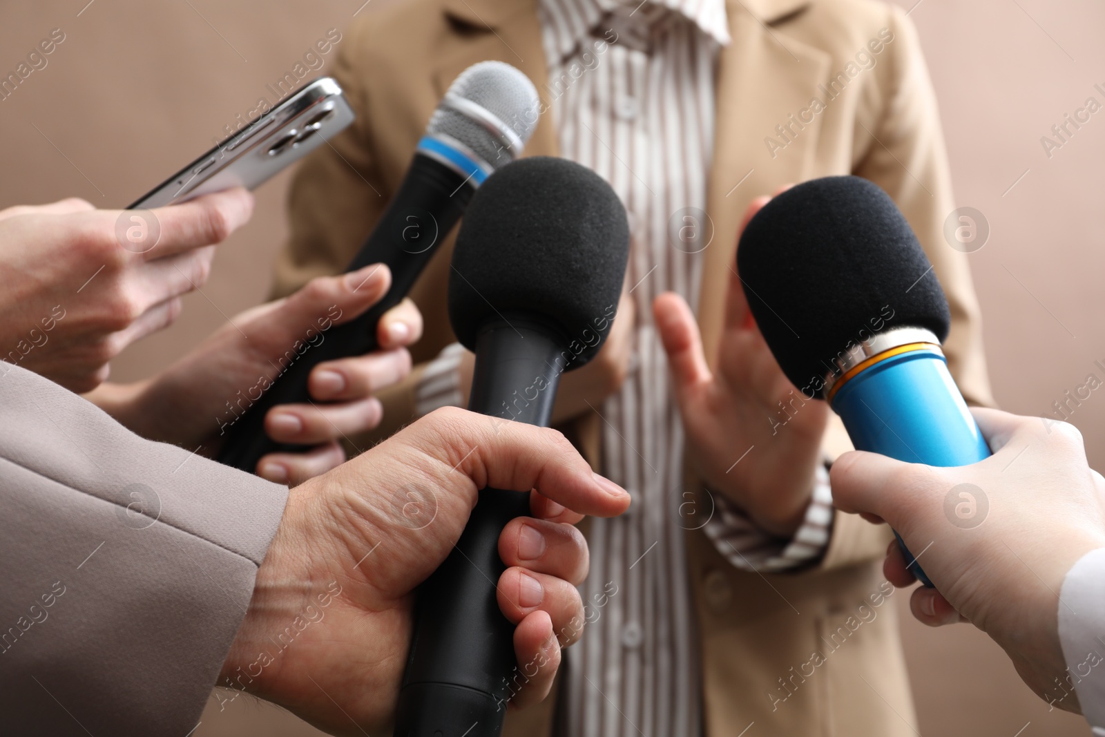 Photo of Group of journalists interviewing businesswoman on beige background, closeup