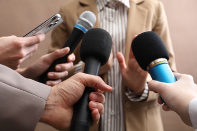 Photo of Group of journalists interviewing businesswoman on beige background, closeup