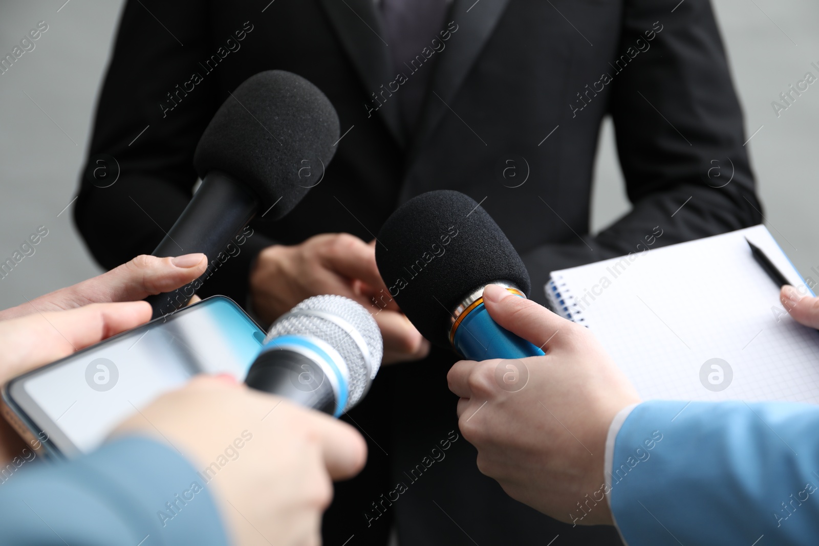 Photo of Group of journalists interviewing businesswoman on grey background, closeup