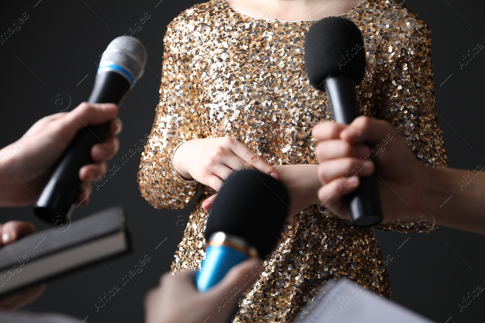 Photo of Group of journalists interviewing celebrity on black background, closeup