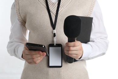 Photo of Journalist with microphones, smartphone and notebook on white background, closeup