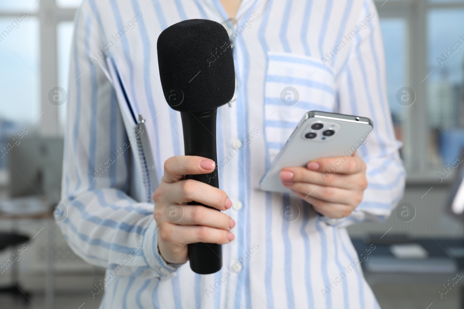 Photo of Journalist with microphone and smartphone indoors, closeup