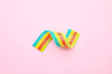 Photo of Tasty rainbow sour belt on pink background, top view