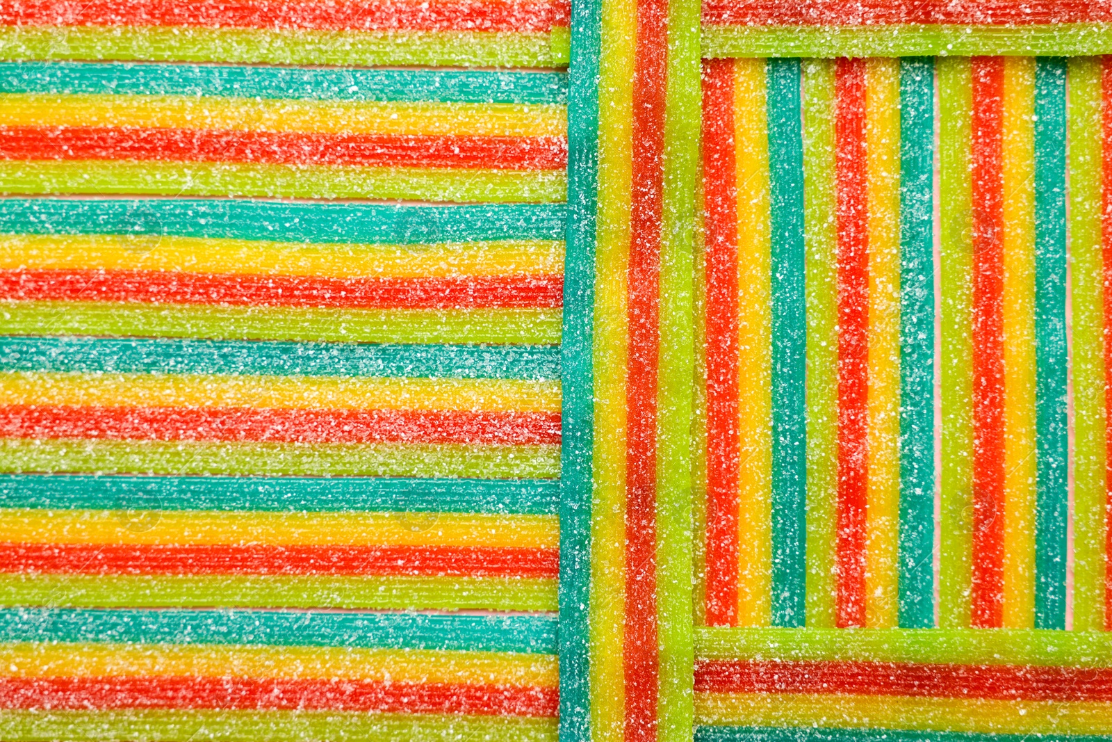 Photo of Tasty rainbow sour belts as background, top view