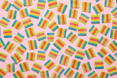 Photo of Tasty rainbow sour belts on pink background, top view