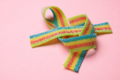 Photo of Tasty rainbow sour belts on pink background, closeup