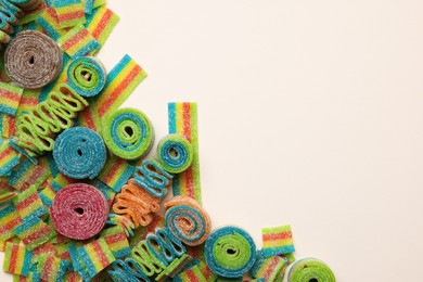 Photo of Different tasty sour belts on beige background, top view. Space for text