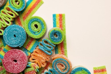 Photo of Different tasty sour belts on beige background, top view. Space for text