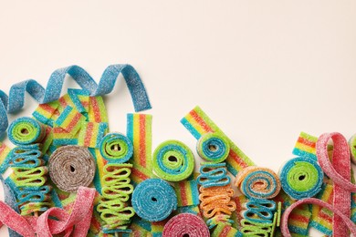 Photo of Different tasty sour belts on beige background, top view