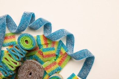 Photo of Different tasty sour belts on beige background, top view