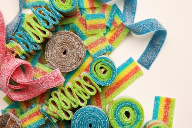 Photo of Different tasty sour belts on beige background, top view