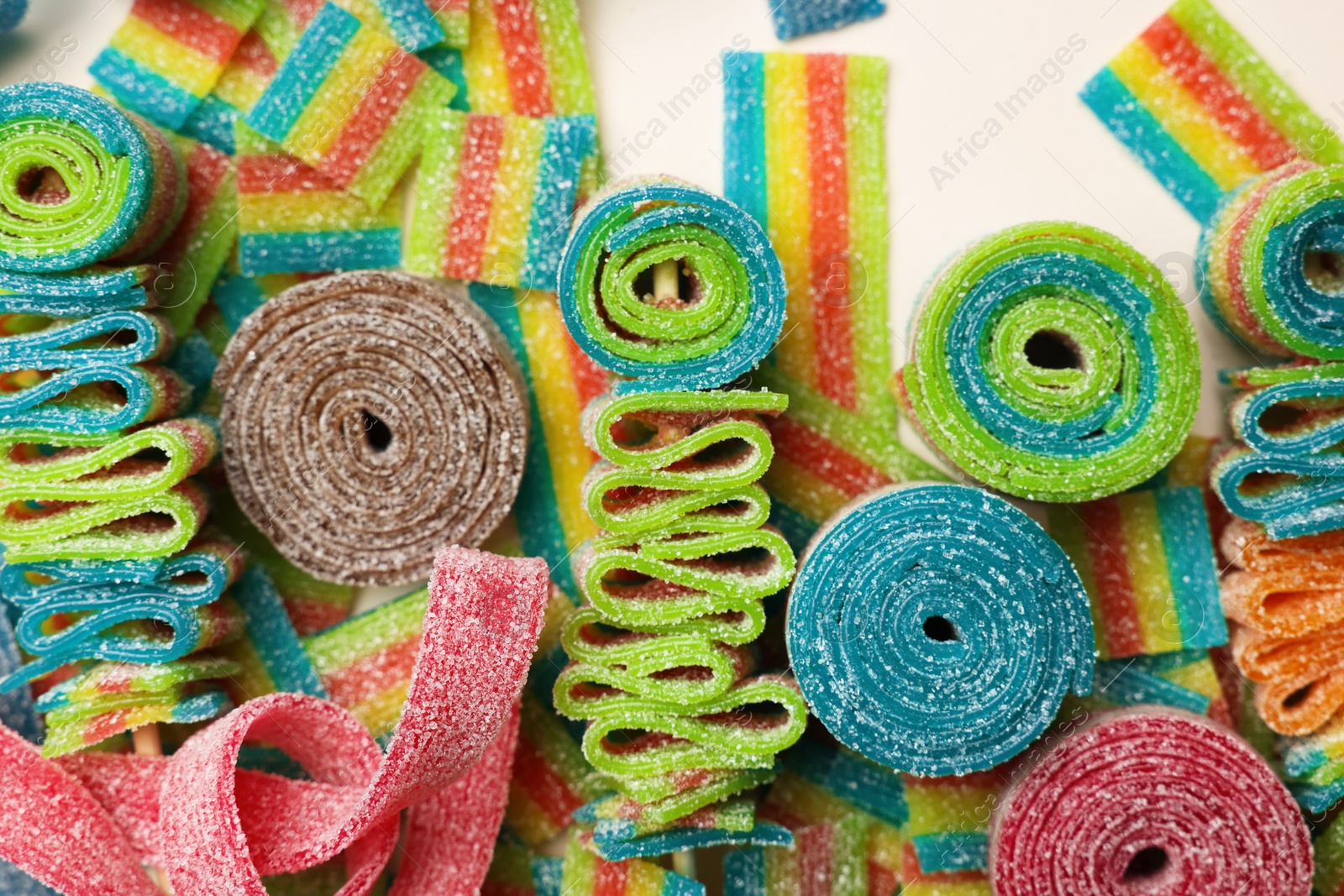 Photo of Different tasty sour belts on beige background, top view