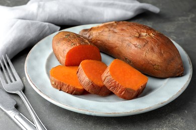 Tasty cooked sweet potatoes served on grey table