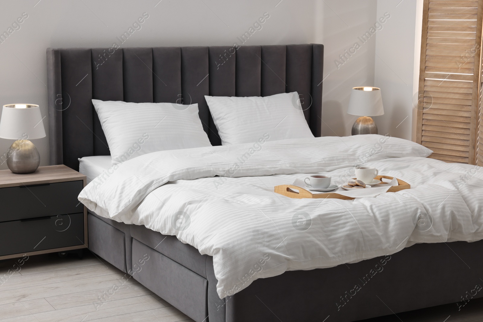 Photo of Breakfast tray on bed with beautiful linens indoors