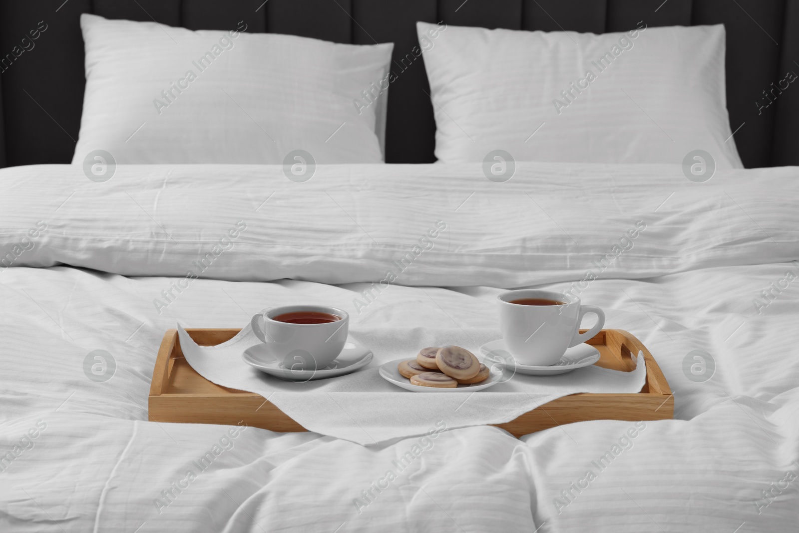 Photo of Breakfast tray on bed with beautiful linens indoors