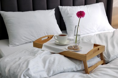 Photo of Breakfast tray on bed with beautiful linens indoors