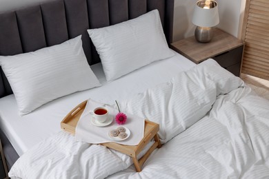 Photo of Breakfast tray on bed with beautiful linens indoors