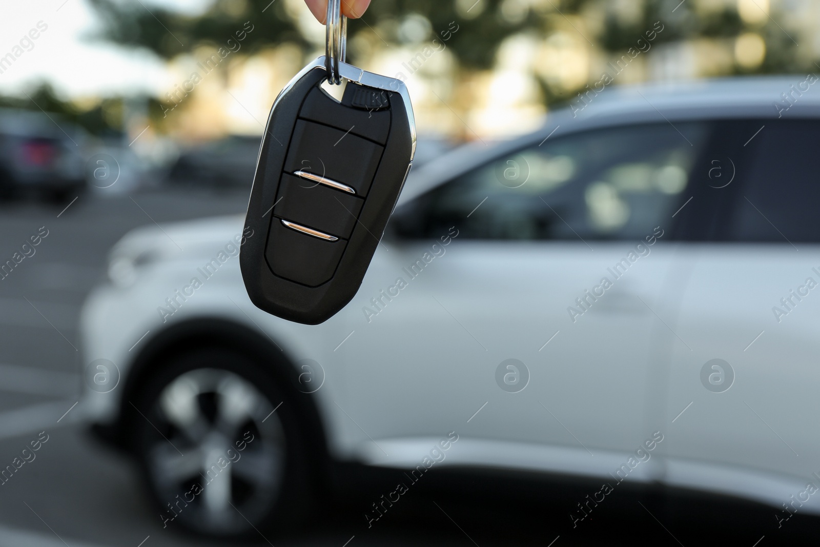 Photo of Woman holding key near car outdoors, closeup