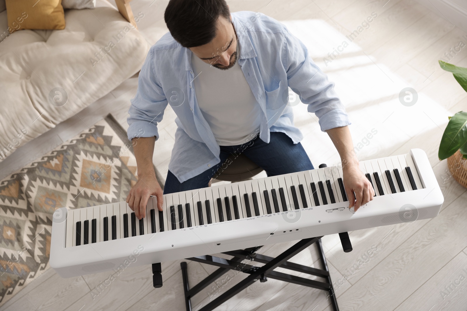 Photo of Man playing synthesizer at home, above view