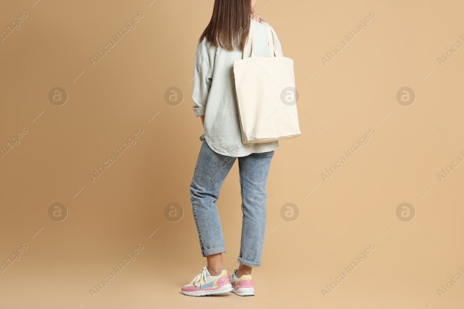 Photo of Woman with blank shopper bag on color background, closeup. Mockup for design