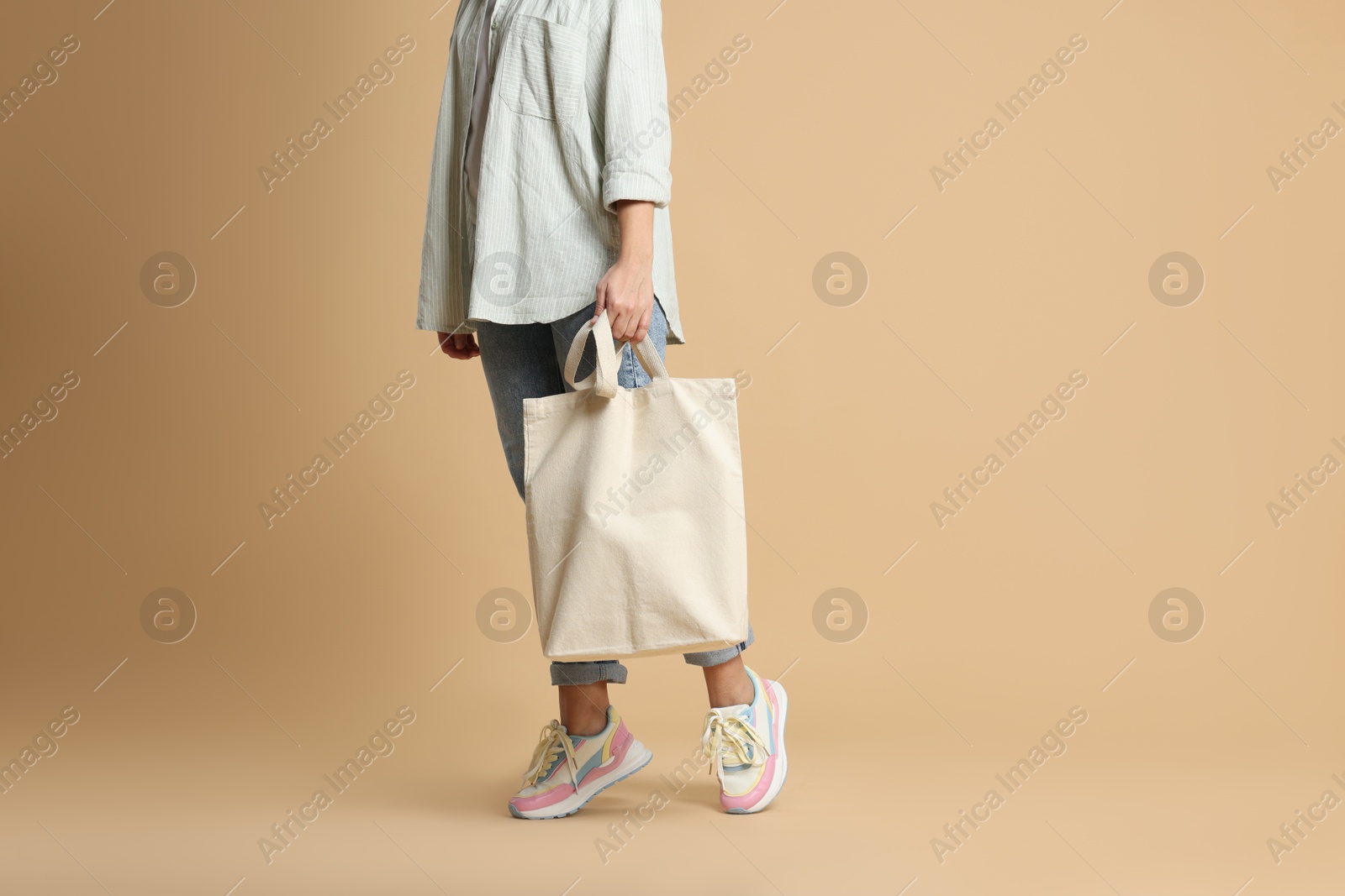 Photo of Woman with blank shopper bag on color background, closeup. Mockup for design