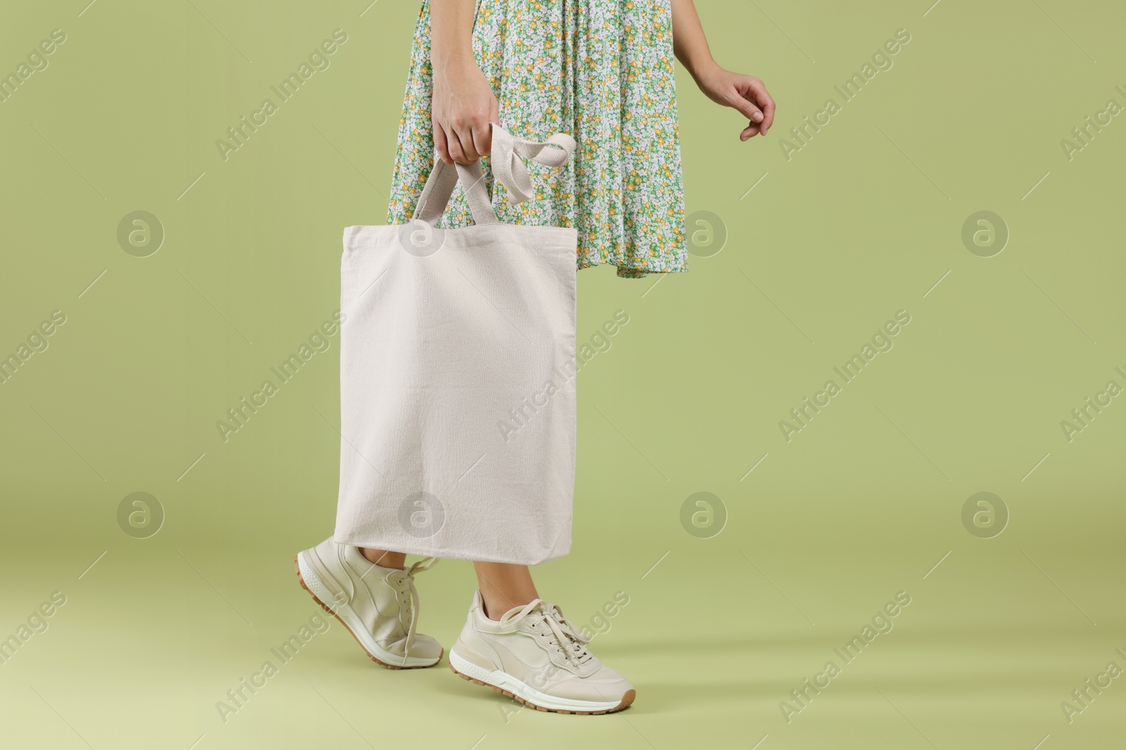 Photo of Woman with blank shopper bag on color background, closeup. Mockup for design