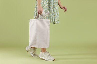 Photo of Woman with blank shopper bag on color background, closeup. Mockup for design