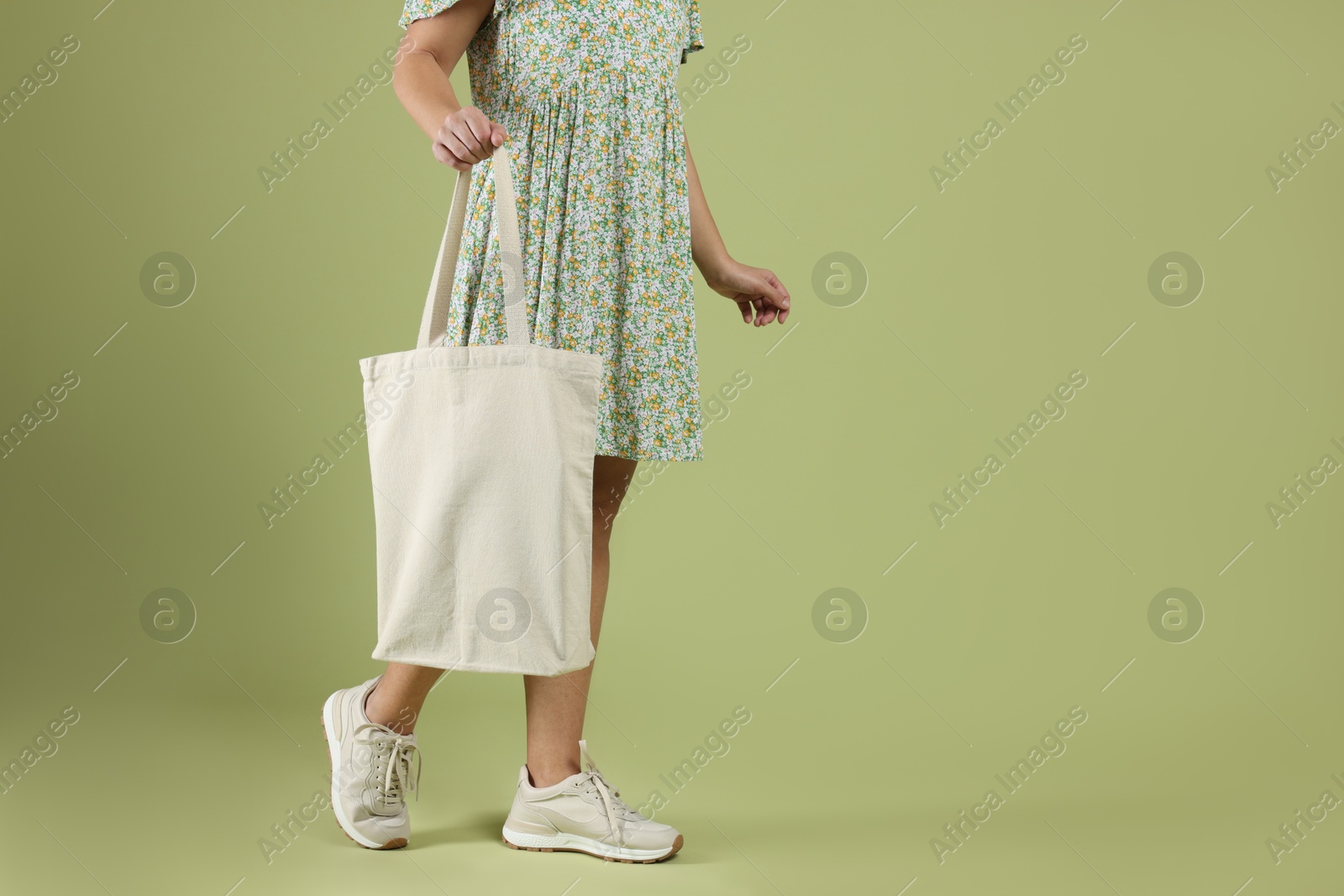 Photo of Woman with blank shopper bag on color background, closeup. Mockup for design