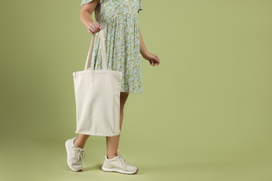 Photo of Woman with blank shopper bag on color background, closeup. Mockup for design