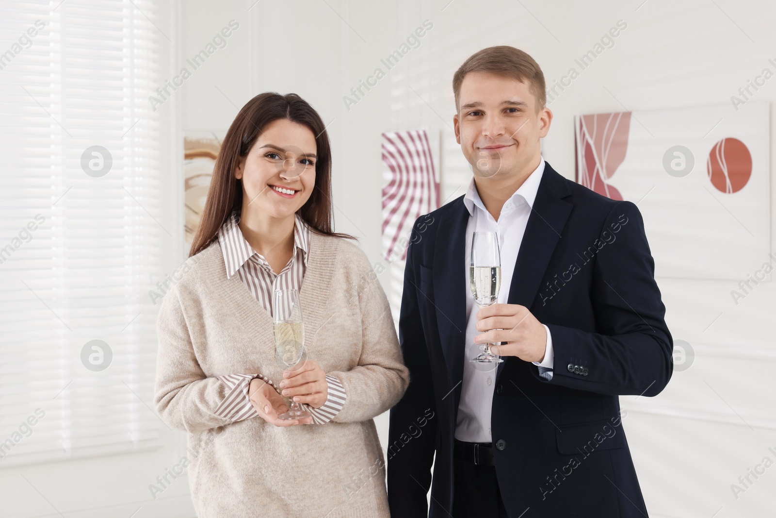 Photo of Couple enjoying art and sparkling wine in gallery