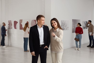 Photo of Happy woman and man visiting art gallery