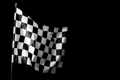 Photo of One racing checkered flag on black background, space for text