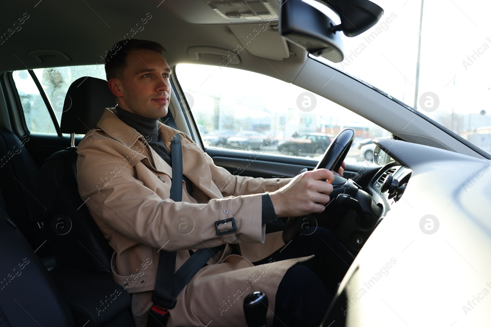 Photo of Driver behind steering wheel of modern car