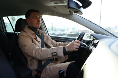 Photo of Driver behind steering wheel of modern car