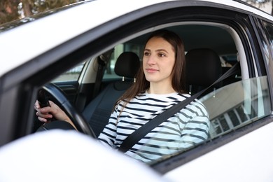 Photo of Driver behind steering wheel of modern car, view from outside