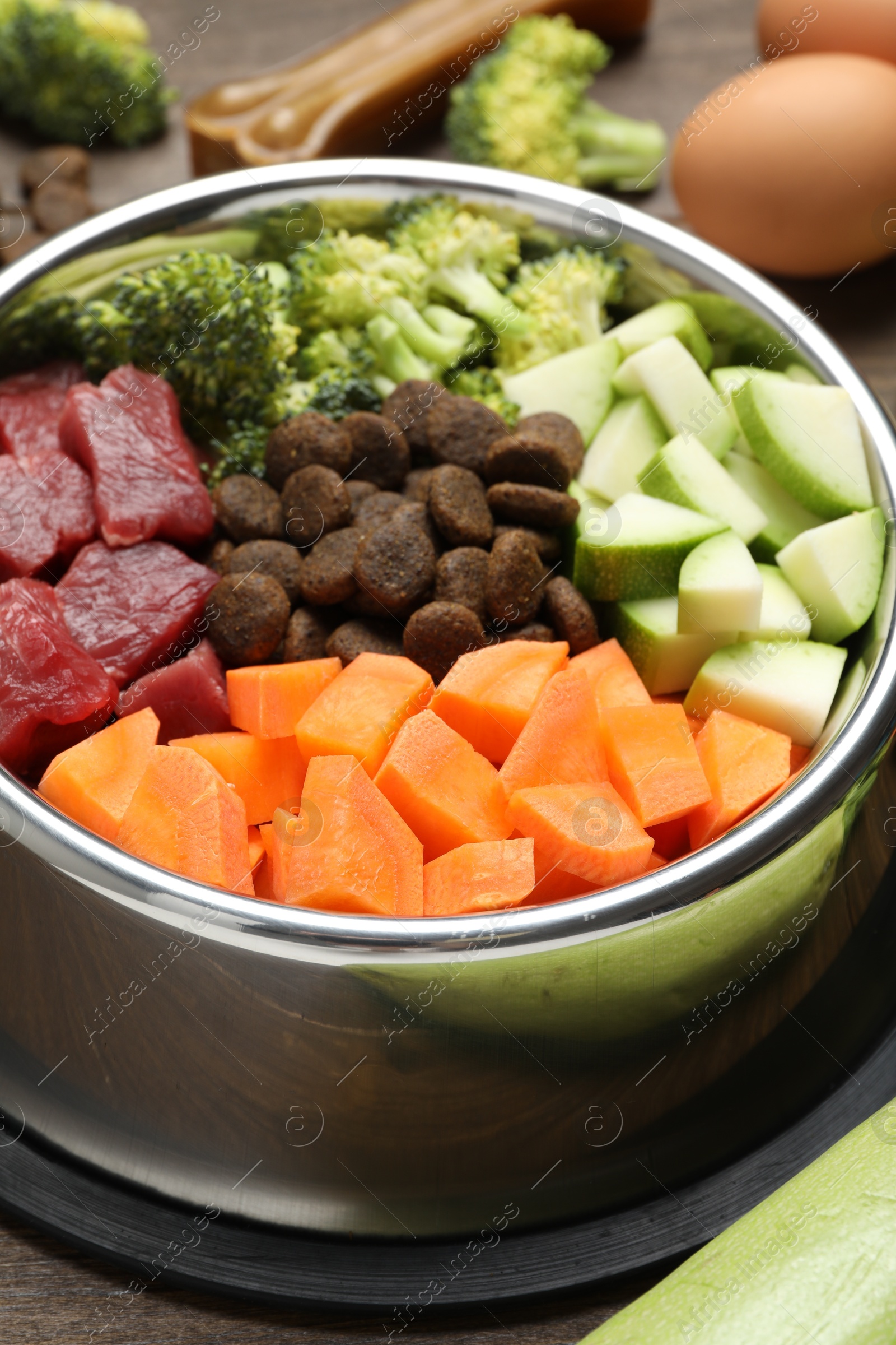 Photo of Dry and natural pet food in feeding bowl on table, closeup