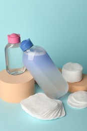 Photo of Clean cotton pads and micellar water on light blue background