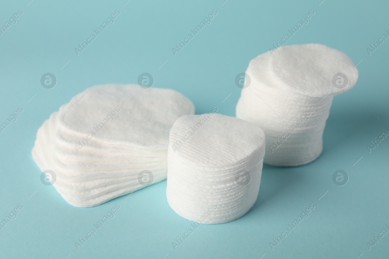 Photo of Clean cotton pads on light blue background, closeup