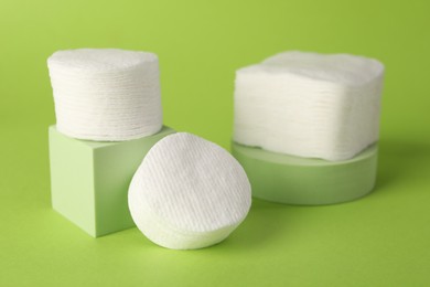 Photo of Clean cotton pads on green background, closeup