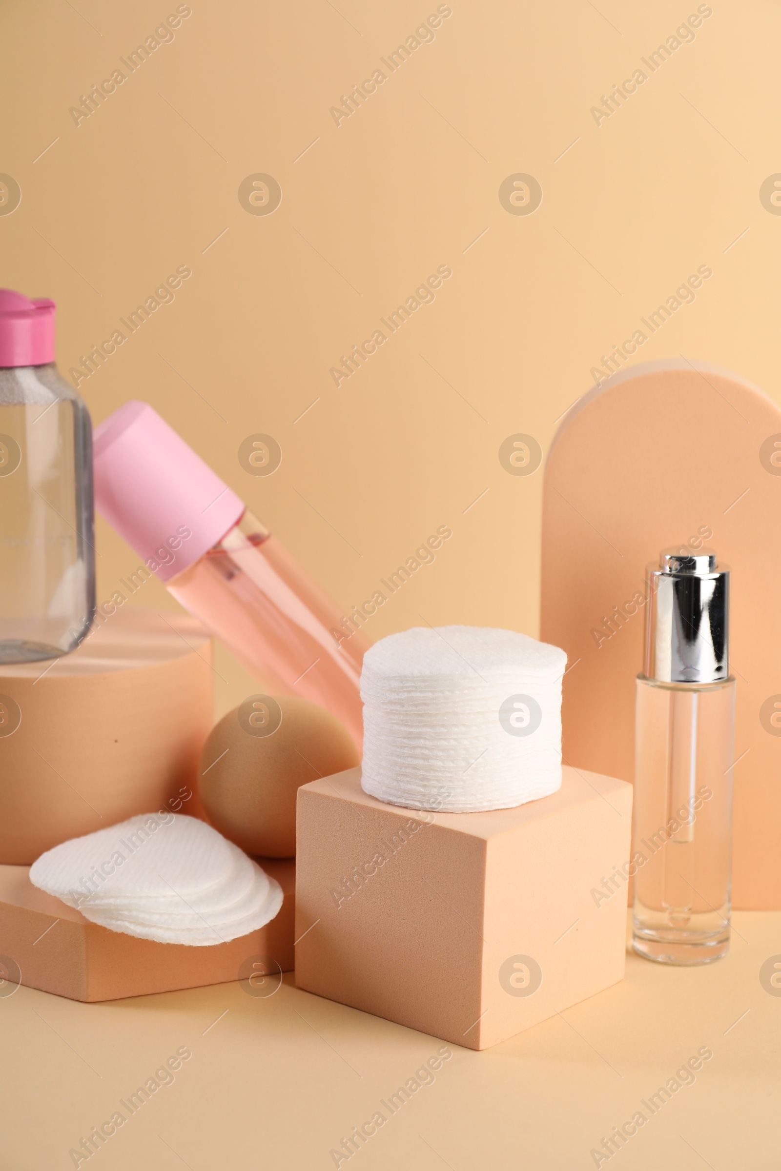 Photo of Clean cotton pads and cosmetic products on beige background