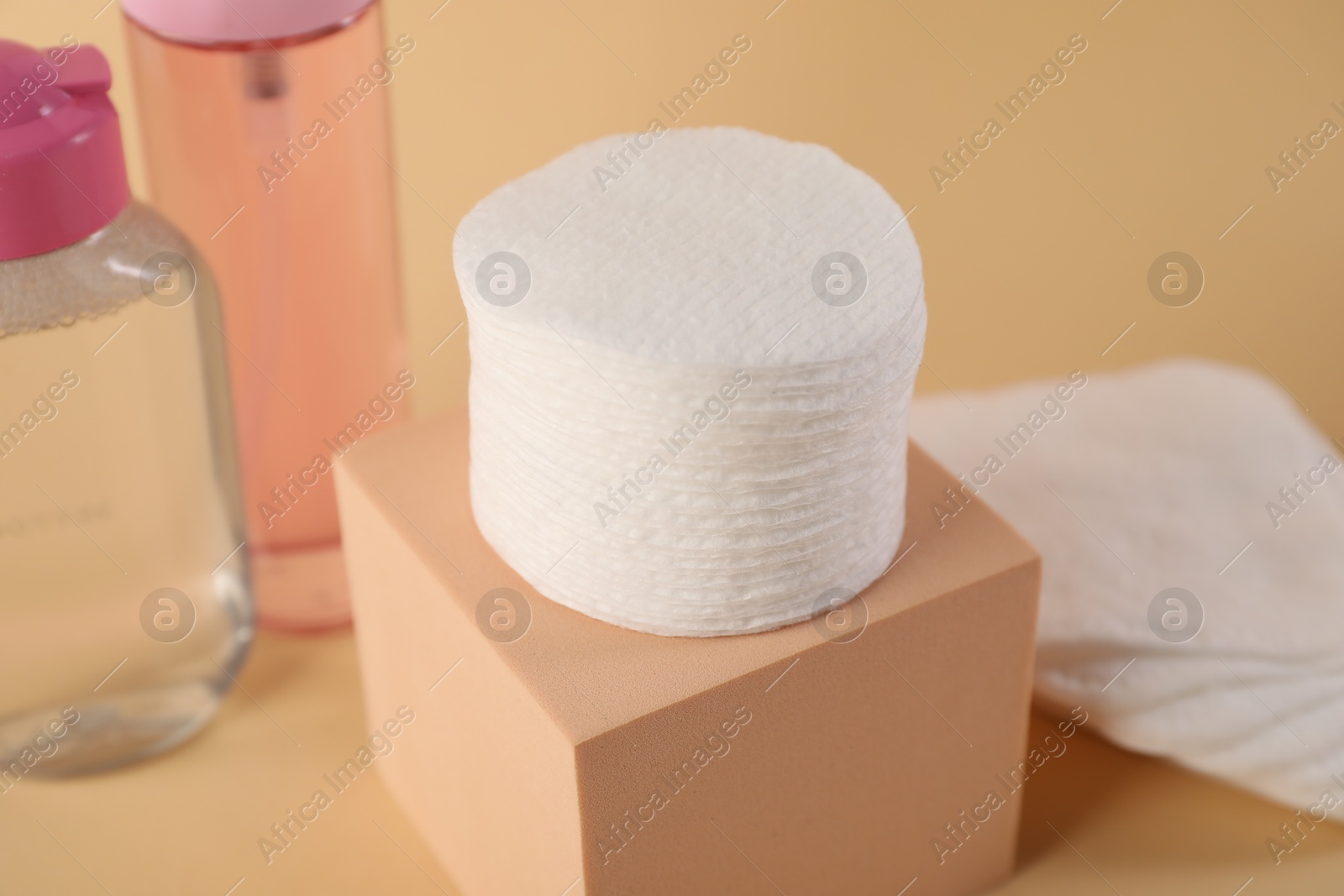 Photo of Clean cotton pads and micellar water on beige background