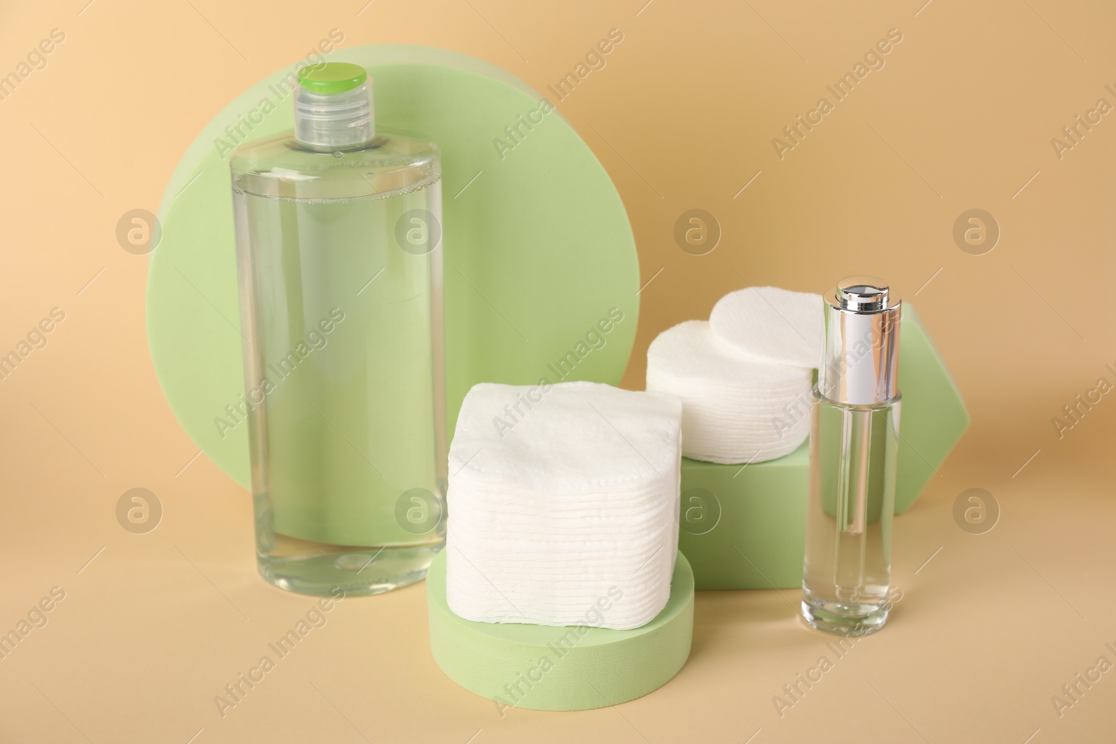 Photo of Clean cotton pads and cosmetic products on beige background