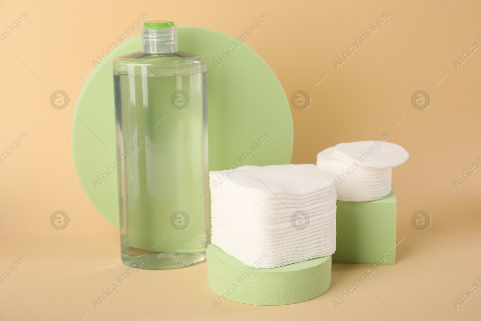 Photo of Clean cotton pads and micellar water on beige background