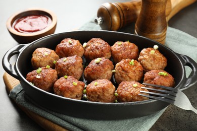 Photo of Tasty meatballs in baking dish served on grey table, closeup