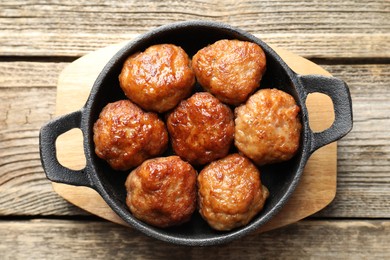 Photo of Tasty meatballs in baking dish on wooden table, top view