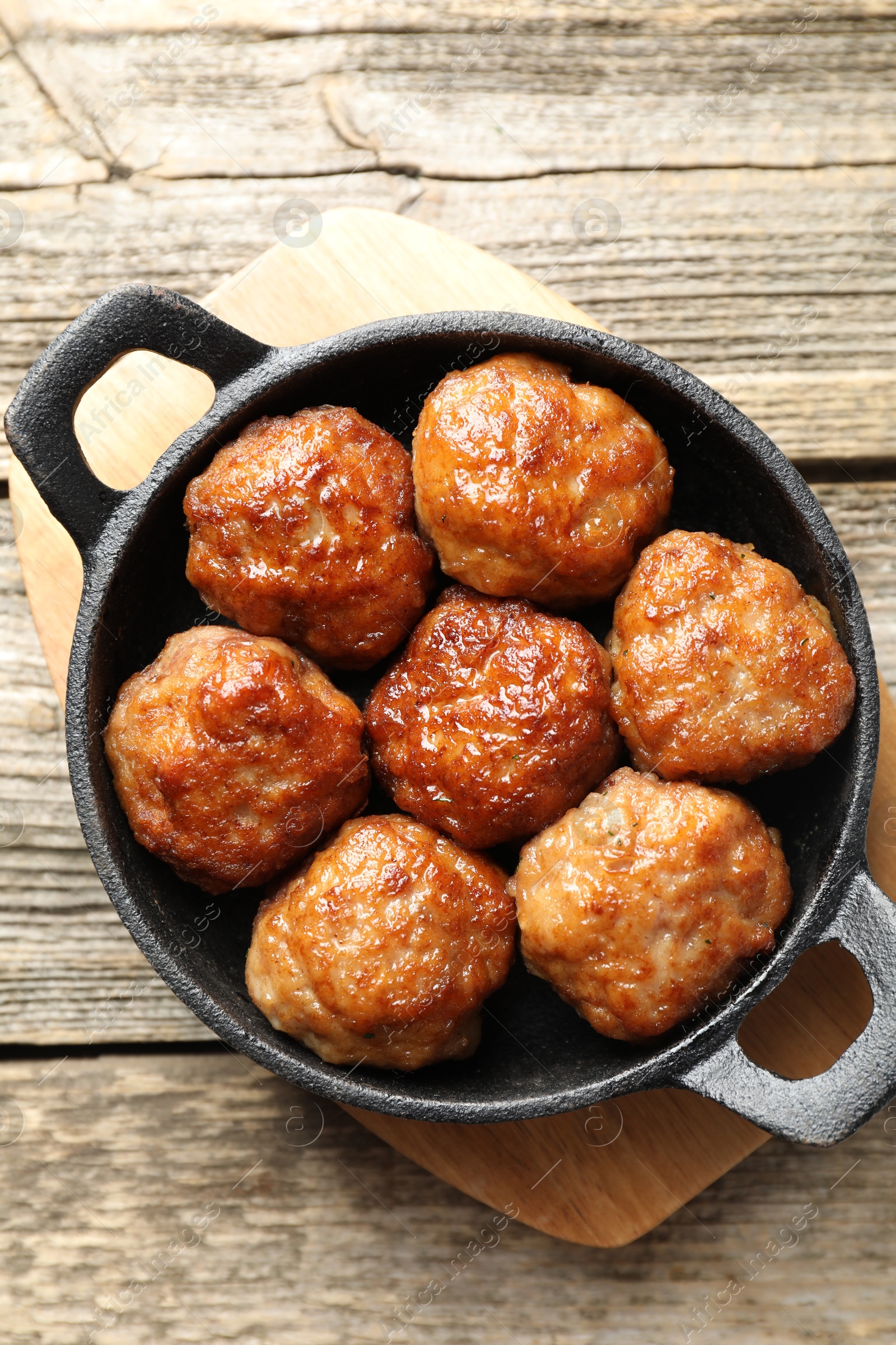 Photo of Tasty meatballs in baking dish on wooden table, top view