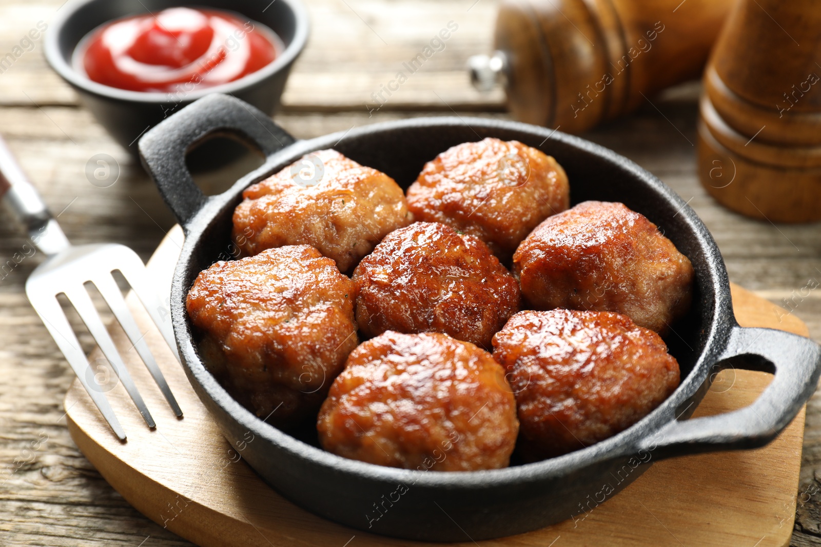 Photo of Tasty meatballs in baking dish served on wooden table, closeup