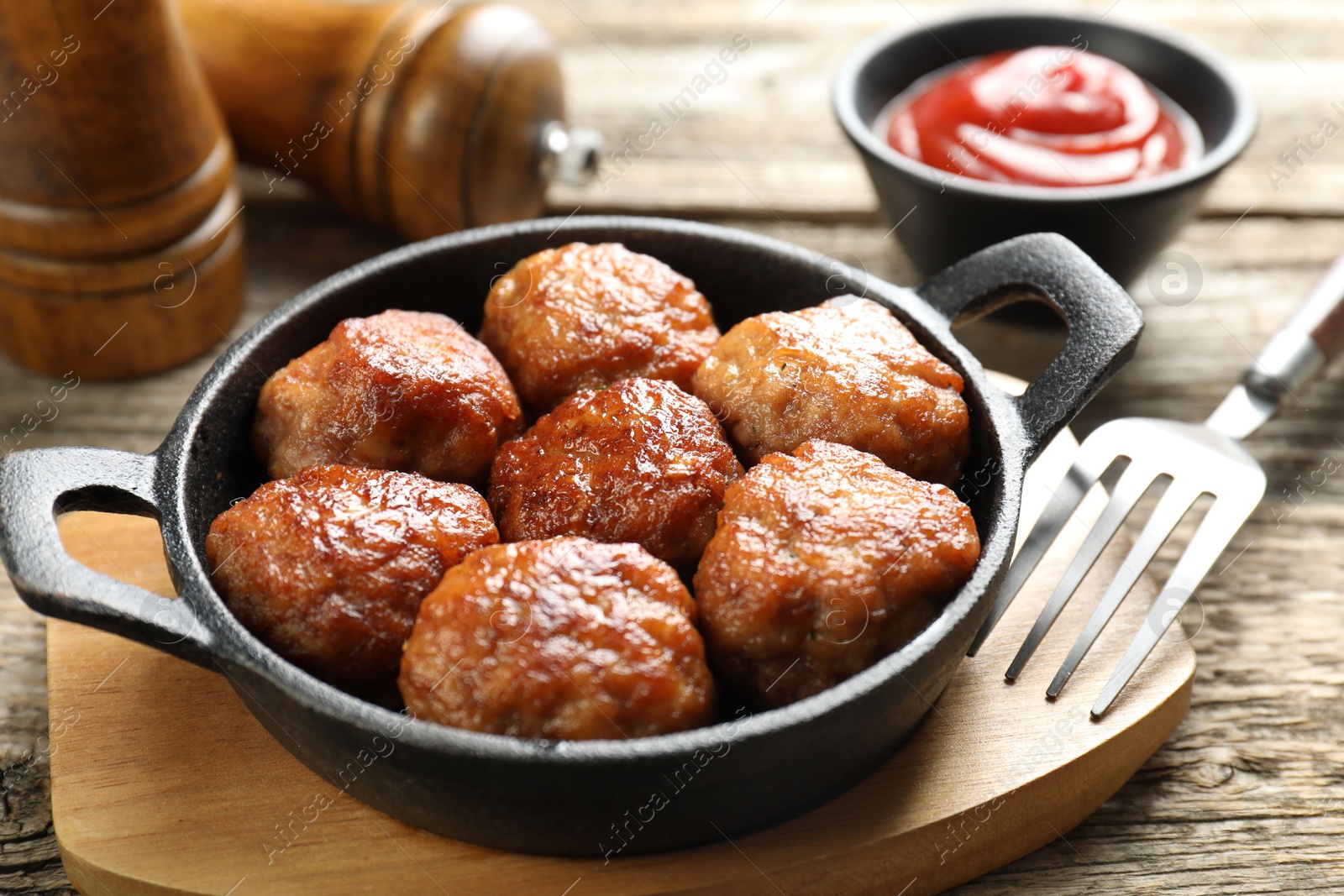 Photo of Tasty meatballs in baking dish served on wooden table, closeup