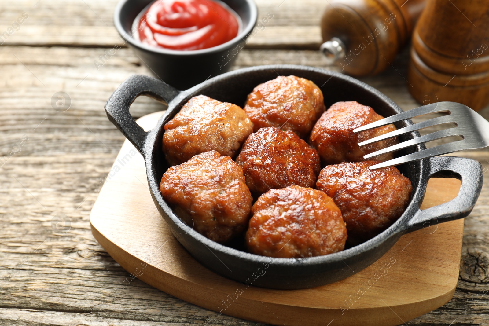 Photo of Tasty meatballs in baking dish served on wooden table, closeup